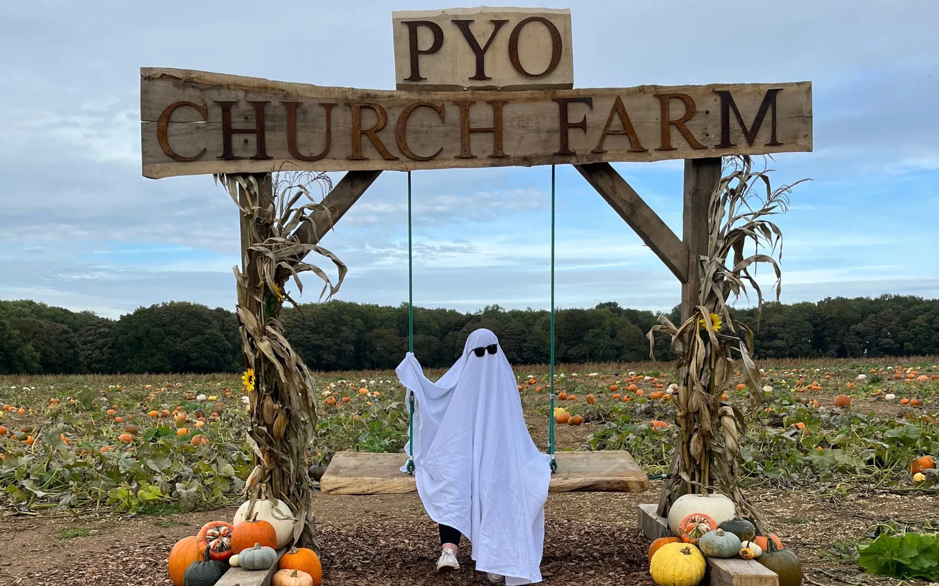 Pumpkin Patch with Rustic Swing and person dressed as a ghost.