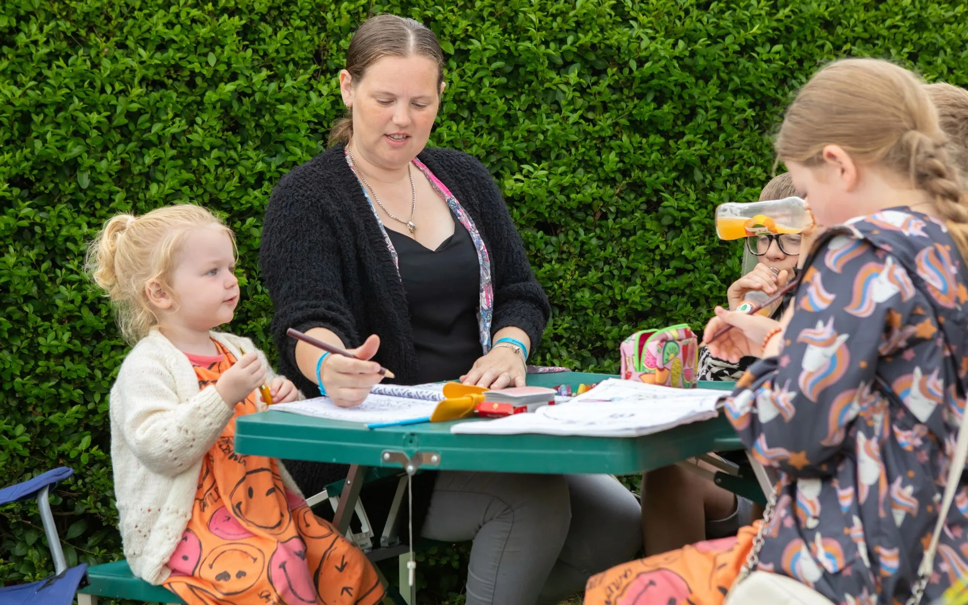 Family enjoying time together outside, gathered around a camping table.